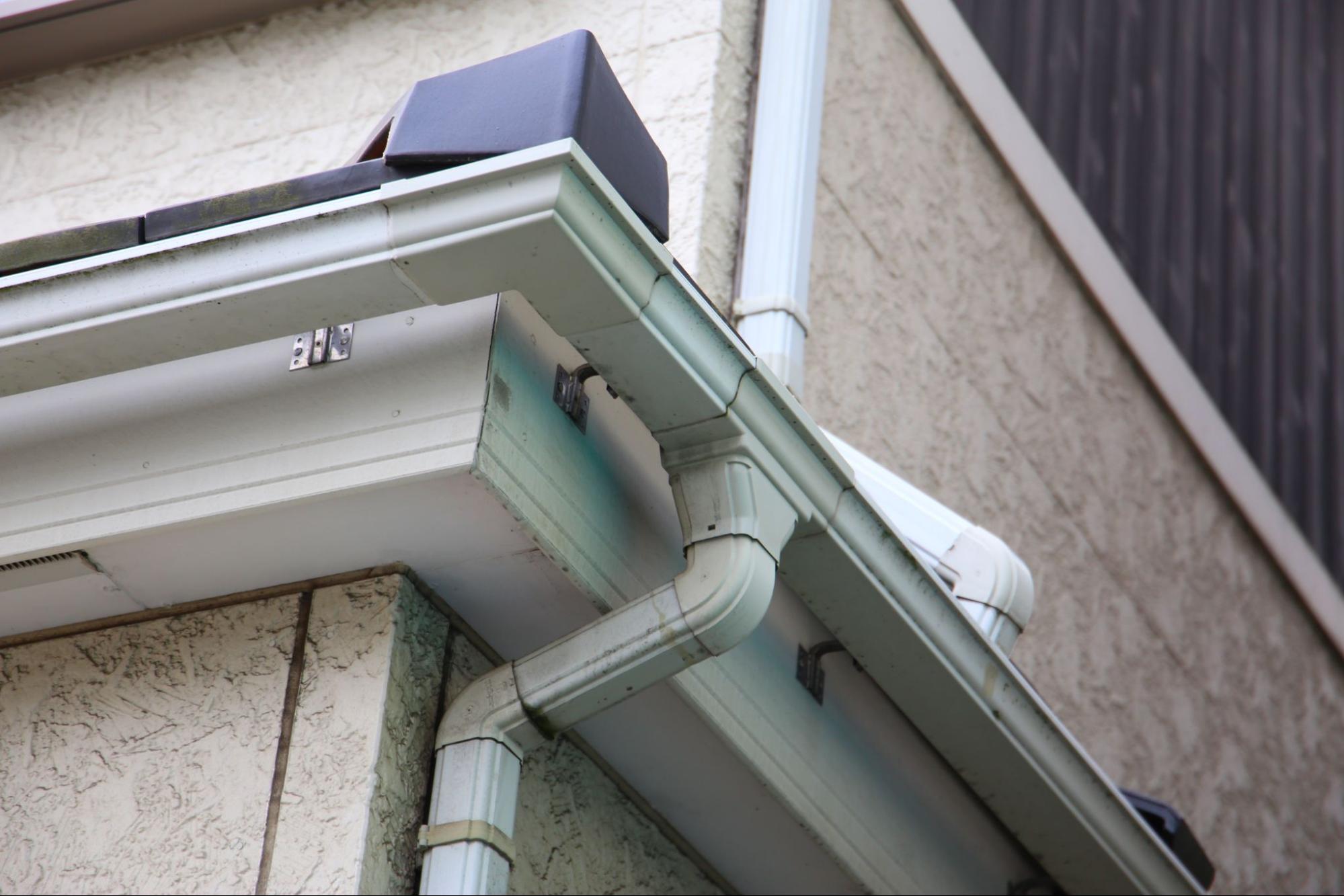 Partial view of a residential gutter system, showing a section of the gutter and downspout for rainwater flow