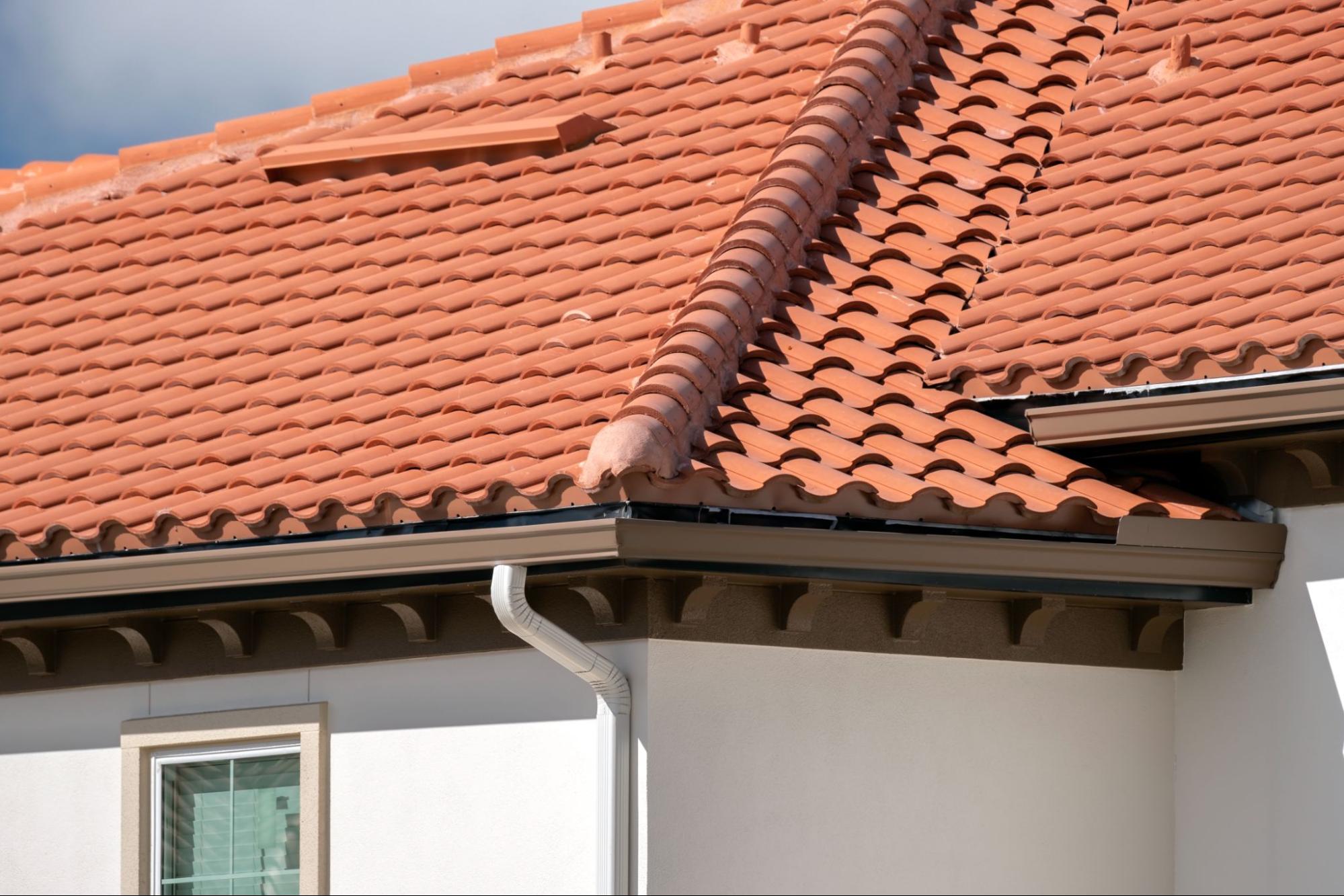 Seamless gutters attached to a ceramic shingle roof, showing clean and secure installation