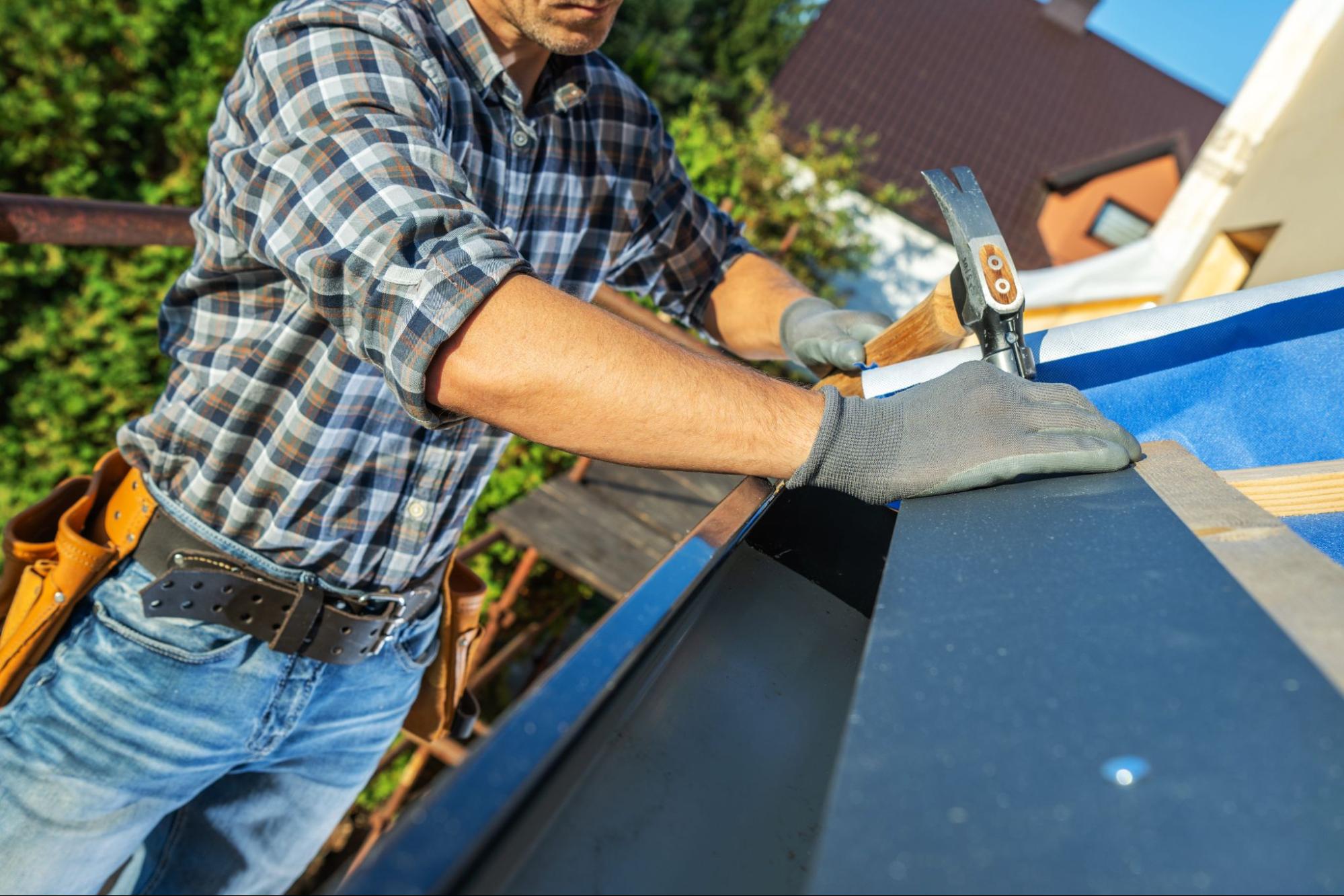 Carpenter preparing roof structure for rain gutter installation