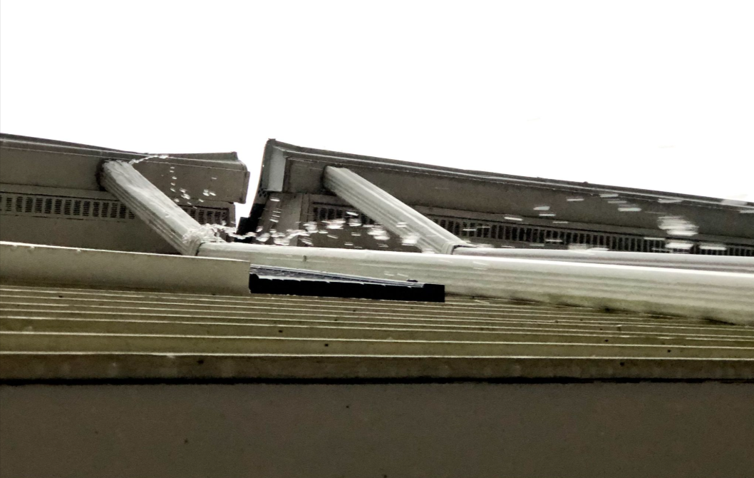 Damaged gutter leaking water during overcast weather