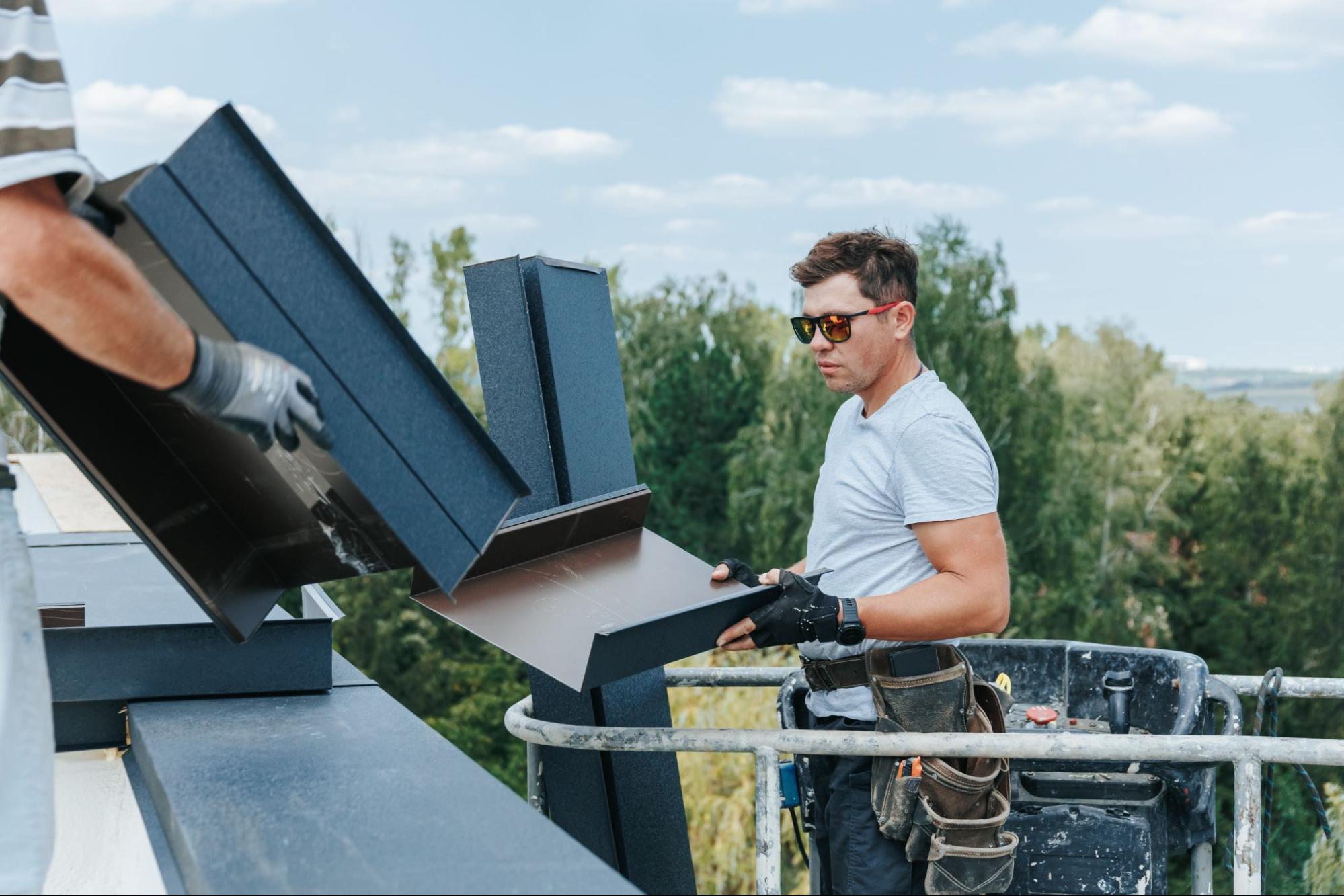 Technician from a gutter installation company checks the materials from an aerial lift