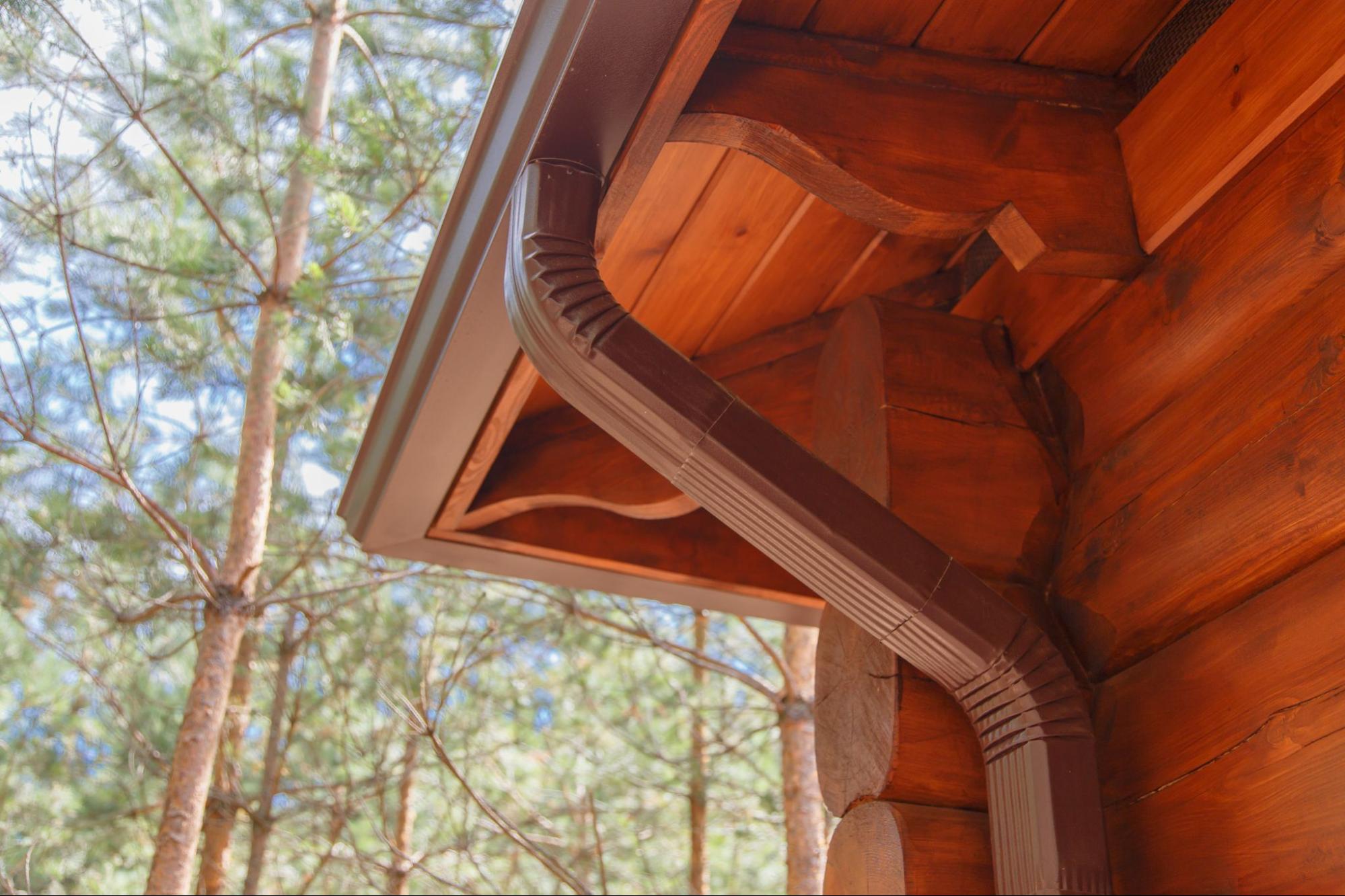 A well-maintained roof gutter system on a log house.