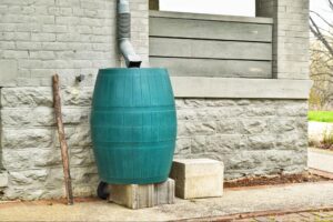 A green rain barrel collecting chlorine-free rainwater from roof runoff