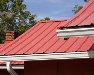 Close-up of a red metal roof featuring a seamless gutter system for efficient rainwater drainage